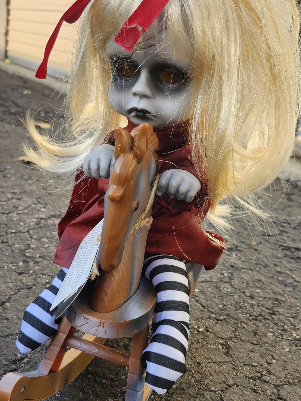 Spooky Blonde Doll in Red Dress with Striped Stockings and Wooden Rocking Horse